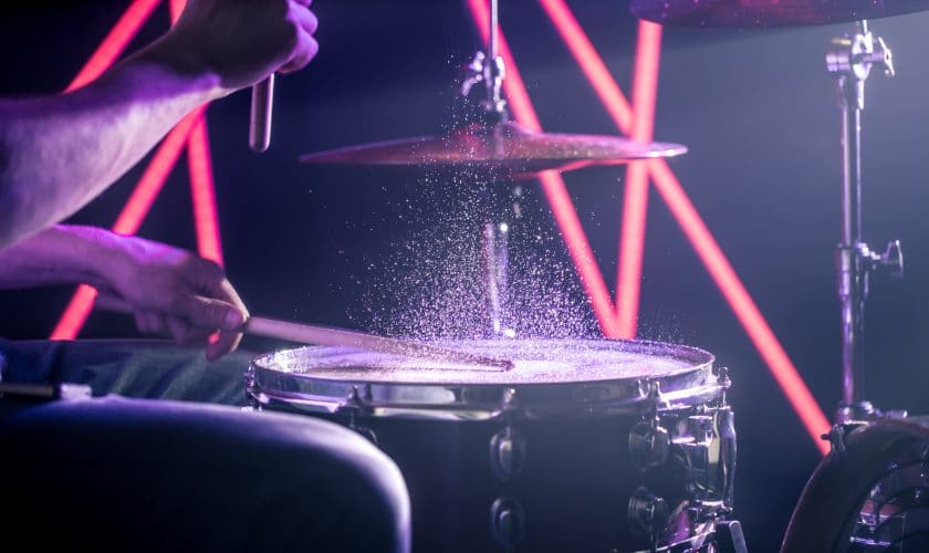 The Man Plays The Drums, On The Background Of Colored Lights