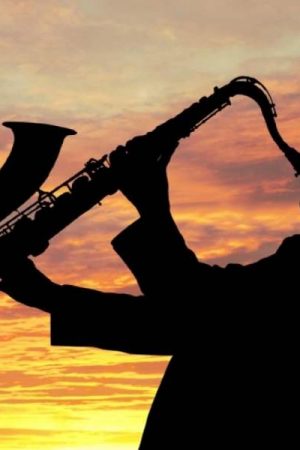 jazzman qui joue du saxo au coucher du soleil