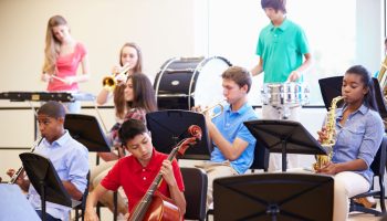 pupils playing musical instruments in school orchestra