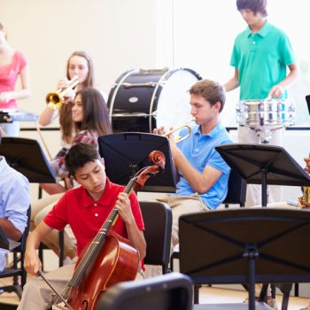 pupils playing musical instruments in school orchestra